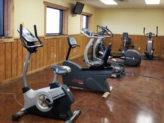 A row of exercise bikes are lined up in a gym