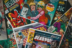 A pile of vibrant Marvel comic book covers featuring characters like Mephisto, Deadpool, and other costumed figures.