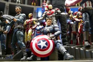 Multiple Captain America and Iron Man action figures arranged in a display, with one Captain America resting on his shield.