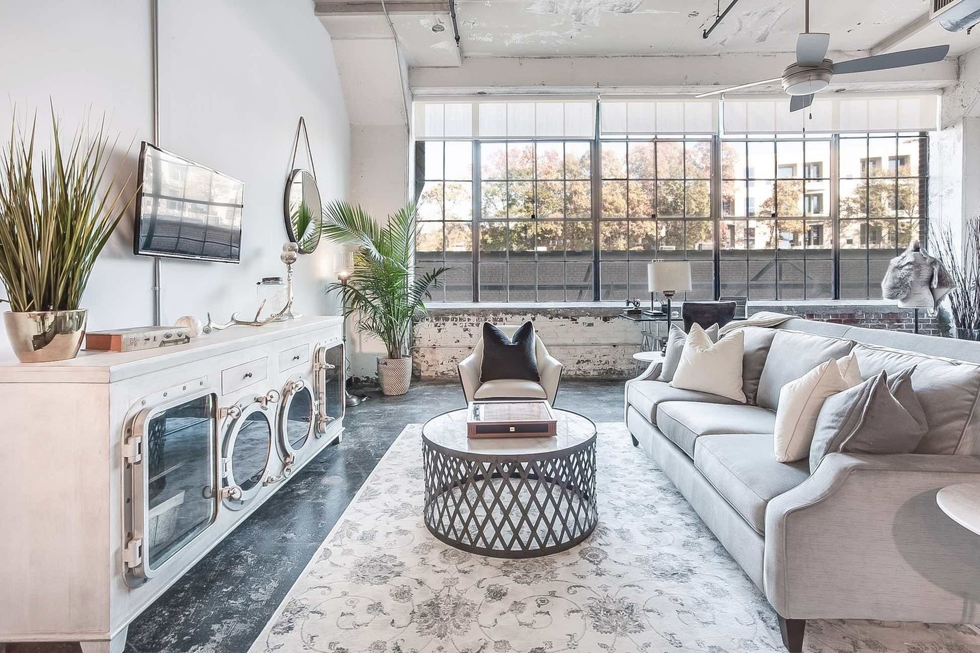 A living room with a couch , table , television and ceiling fan.