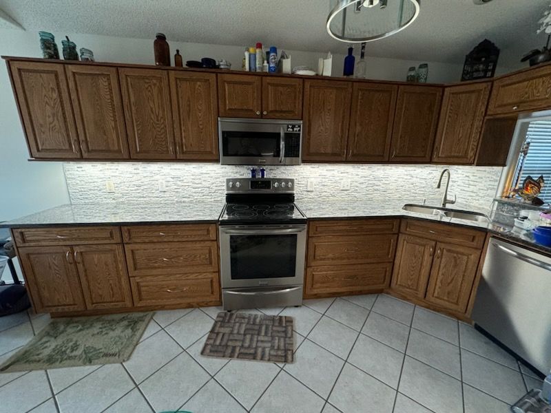 A kitchen with stainless steel appliances and wooden cabinets - Milton, FL - Damn Fine Jobs