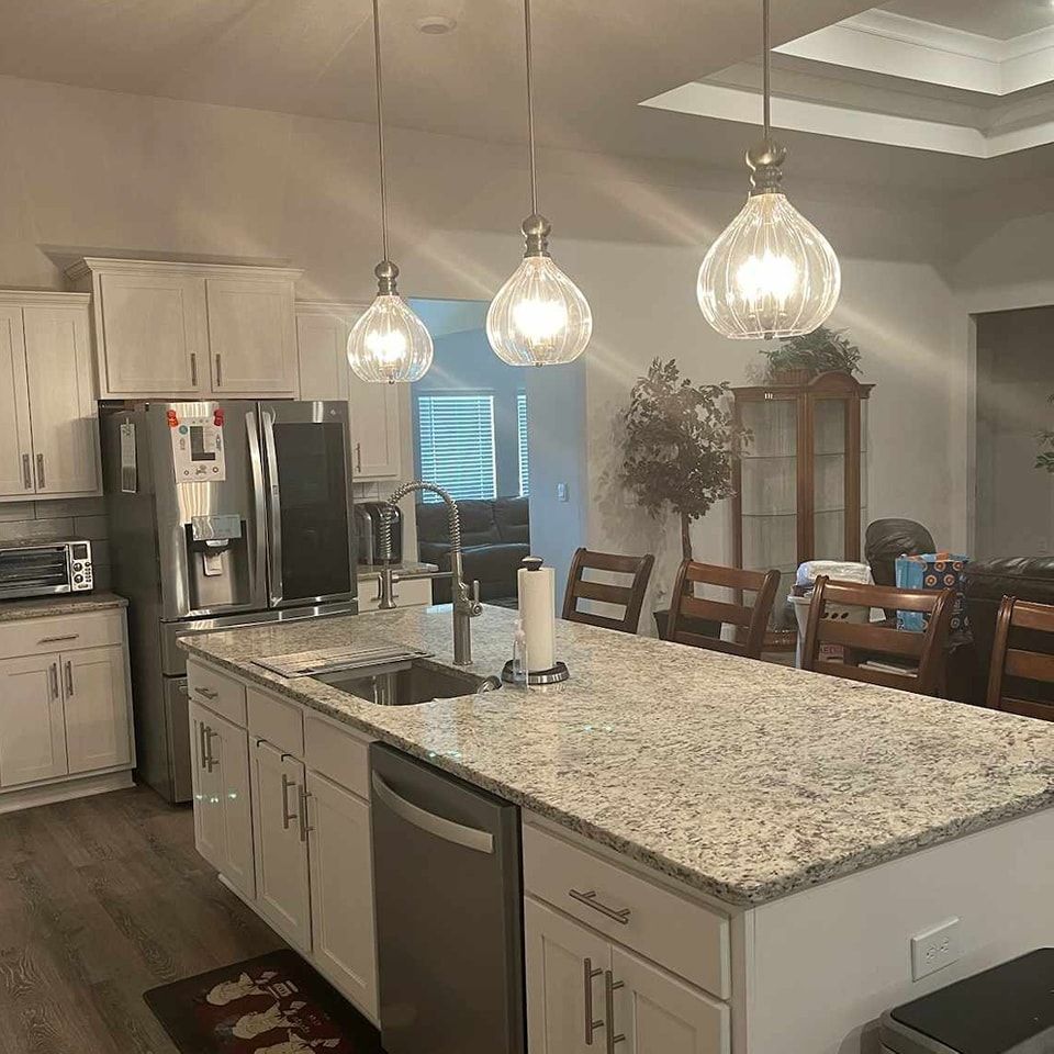 A kitchen with a large island , sink , refrigerator and dishwasher - Milton, FL - Damn Fine Jobs