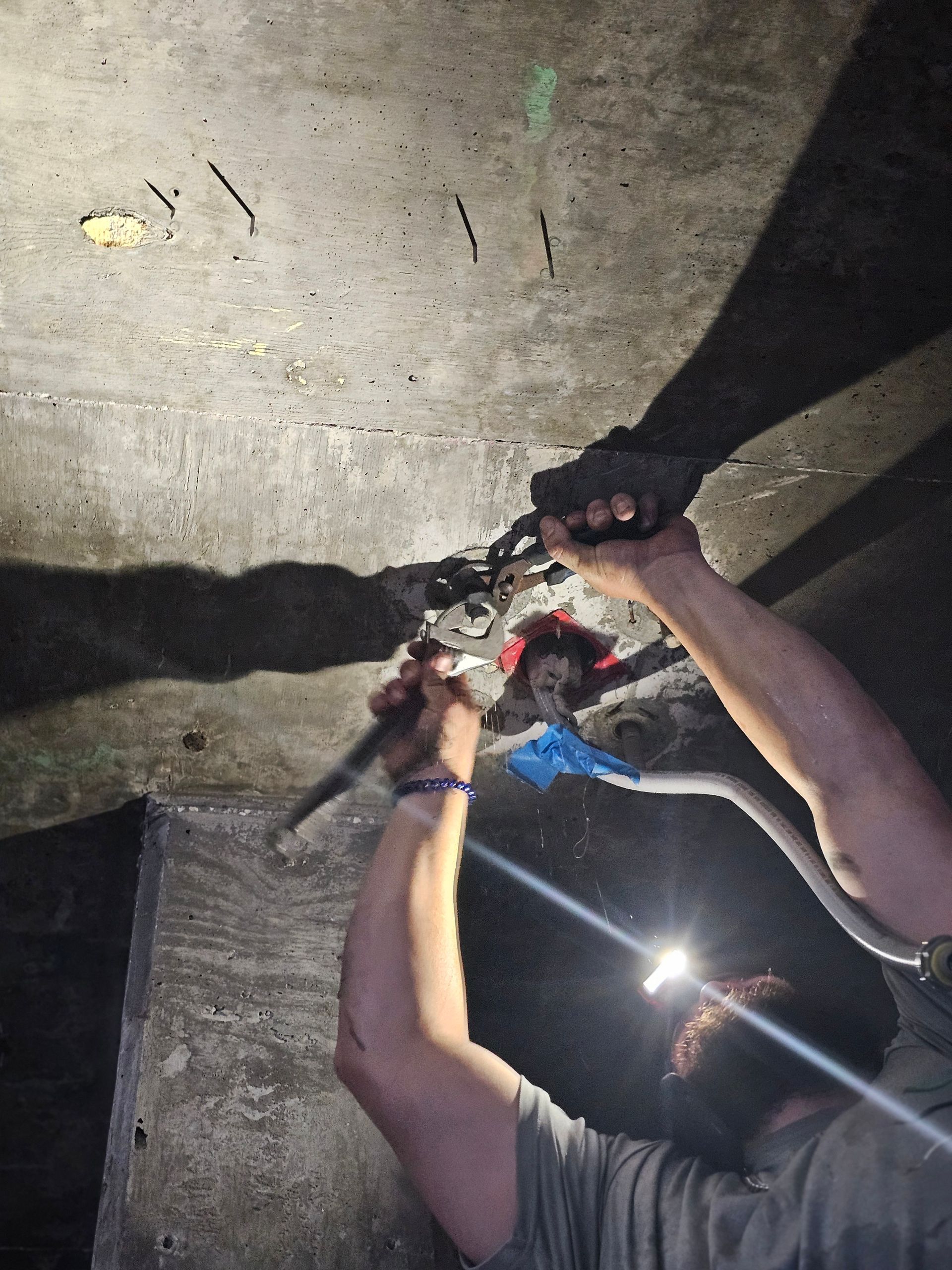 A man is working on a concrete wall with a pair of pliers - Milton, FL - Damn Fine Jobs