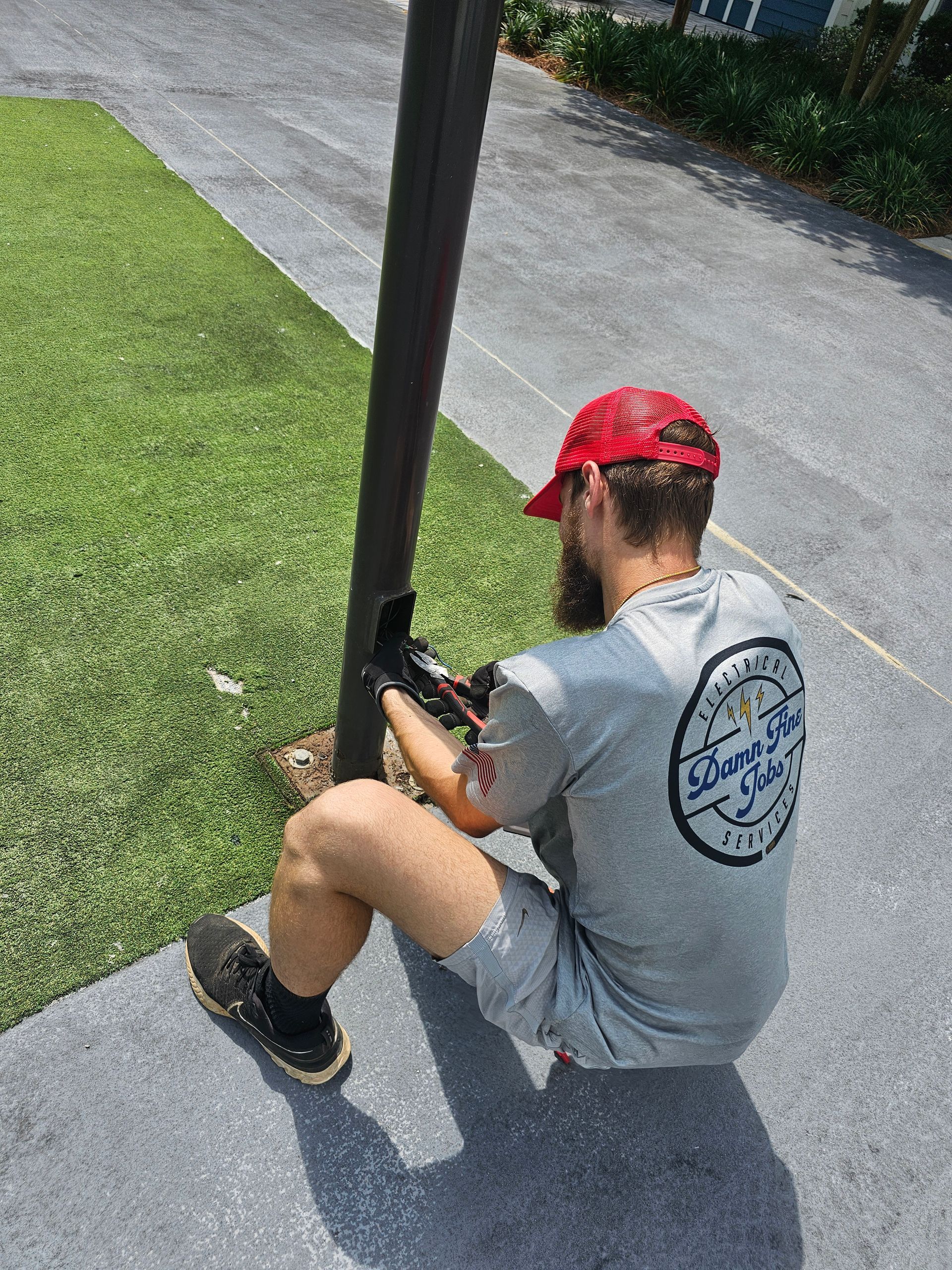 A man is sitting on the ground working on a pole - Milton, FL - Damn Fine Jobs