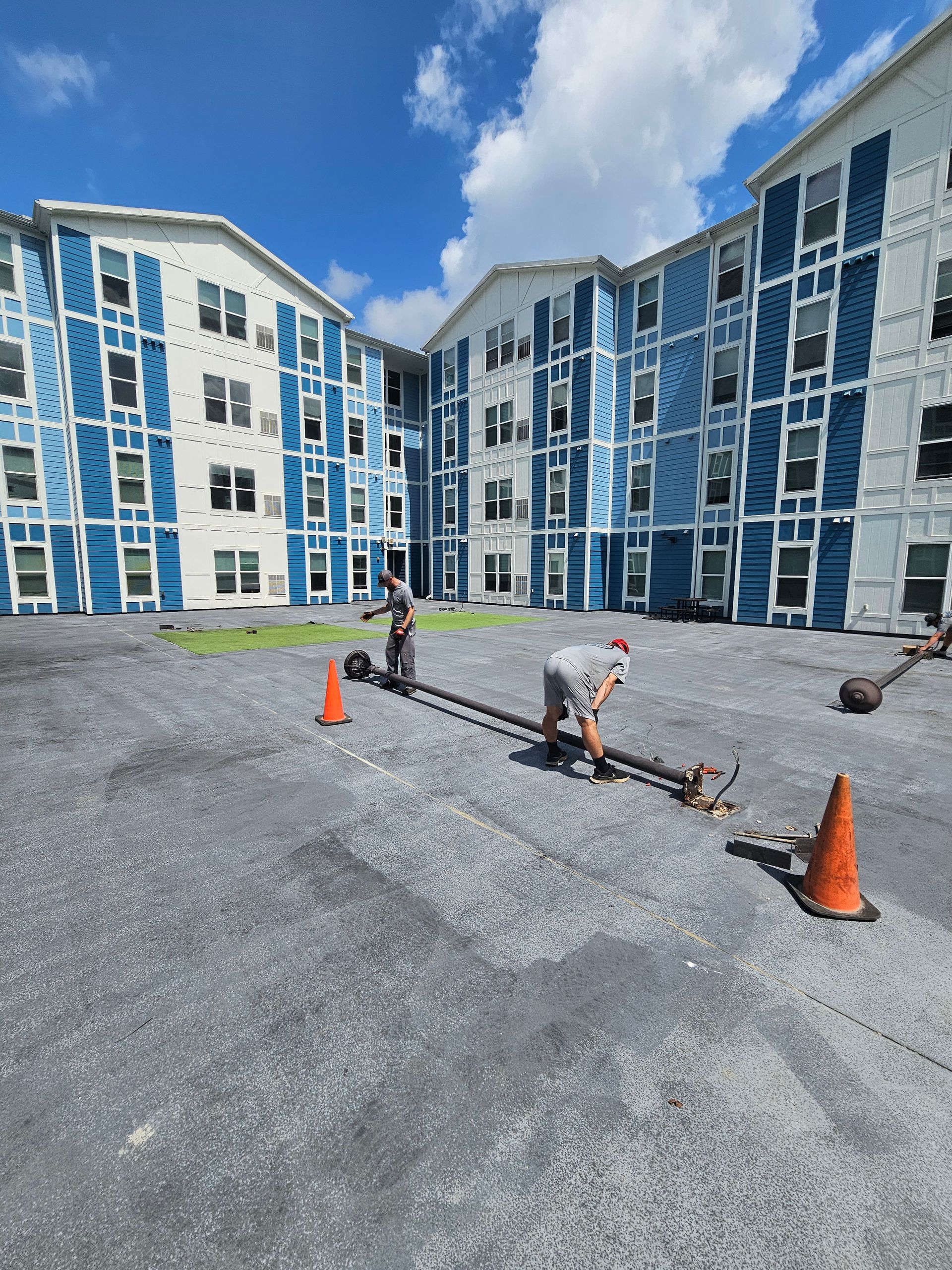 A man is working in a parking lot in front of a large building - Milton, FL - Damn Fine Jobs