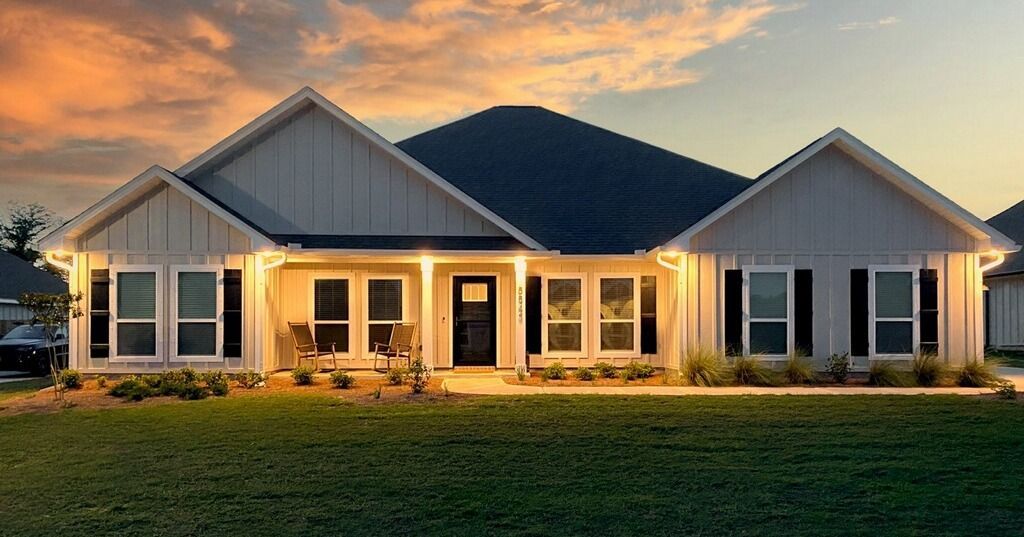 A large white house with a lot of windows is lit up at night - Milton, FL - Damn Fine Jobs