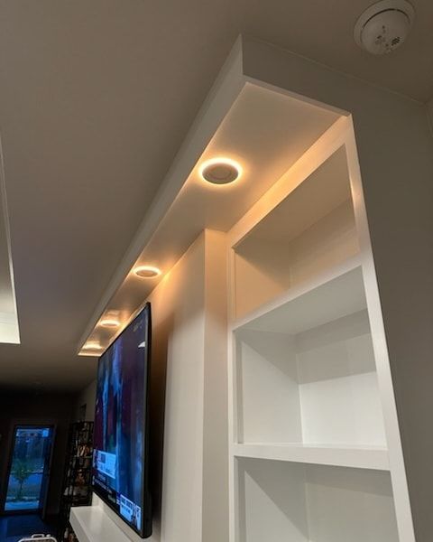 A living room with a flat screen tv and shelves - Milton, FL - Damn Fine Jobs