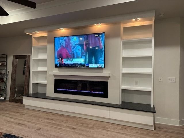 A living room with a fireplace and a flat screen tv - Milton, FL - Damn Fine Jobs