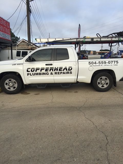 White Copperhead Plumbing & Repairs pickup truck parked on a street, with phone number on the side.