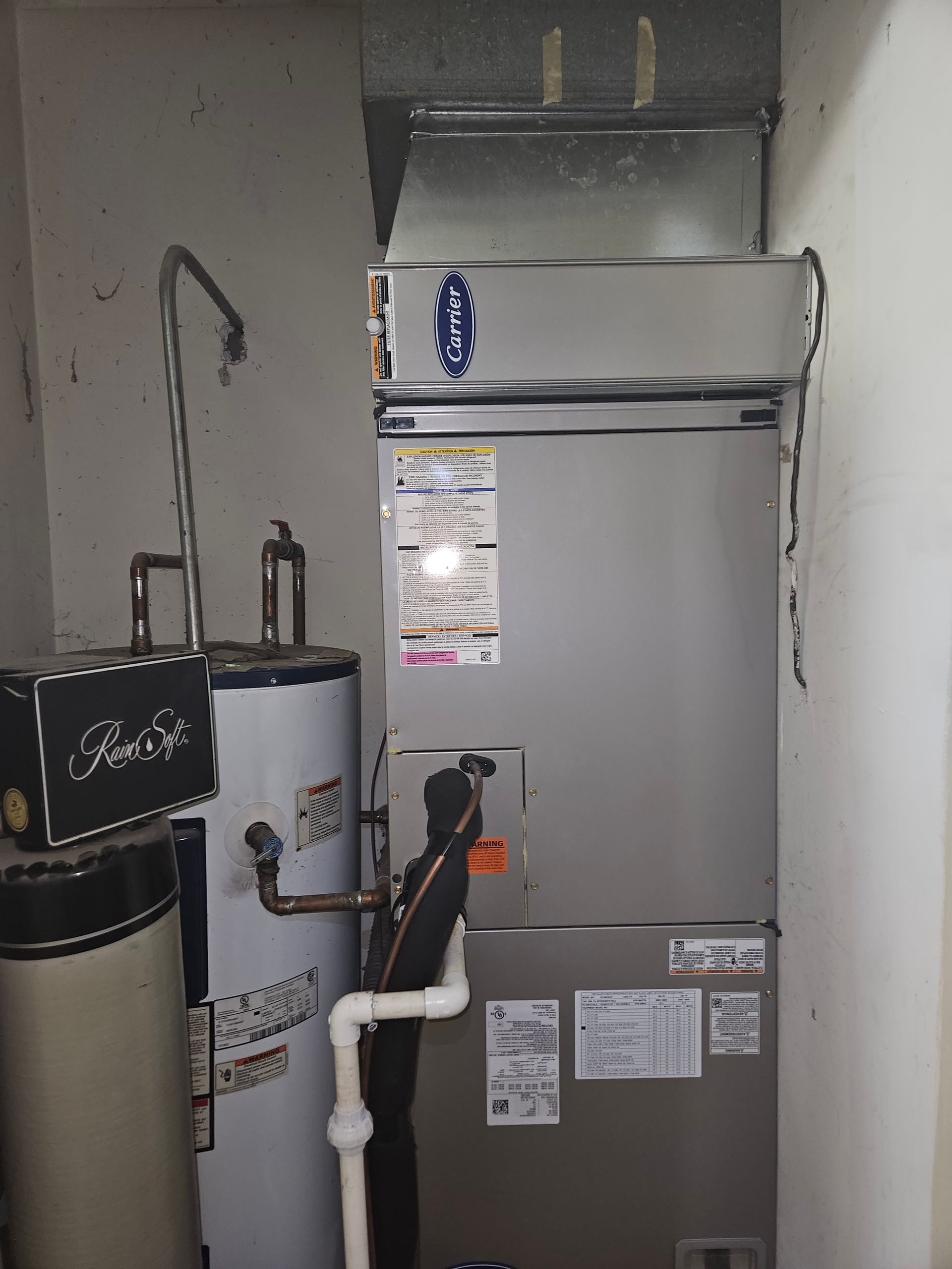 Water heater, furnace, and pipes in a utility room.