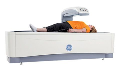 A person is laying on top of a mri machine.