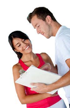 A man and a woman are looking at a clipboard.