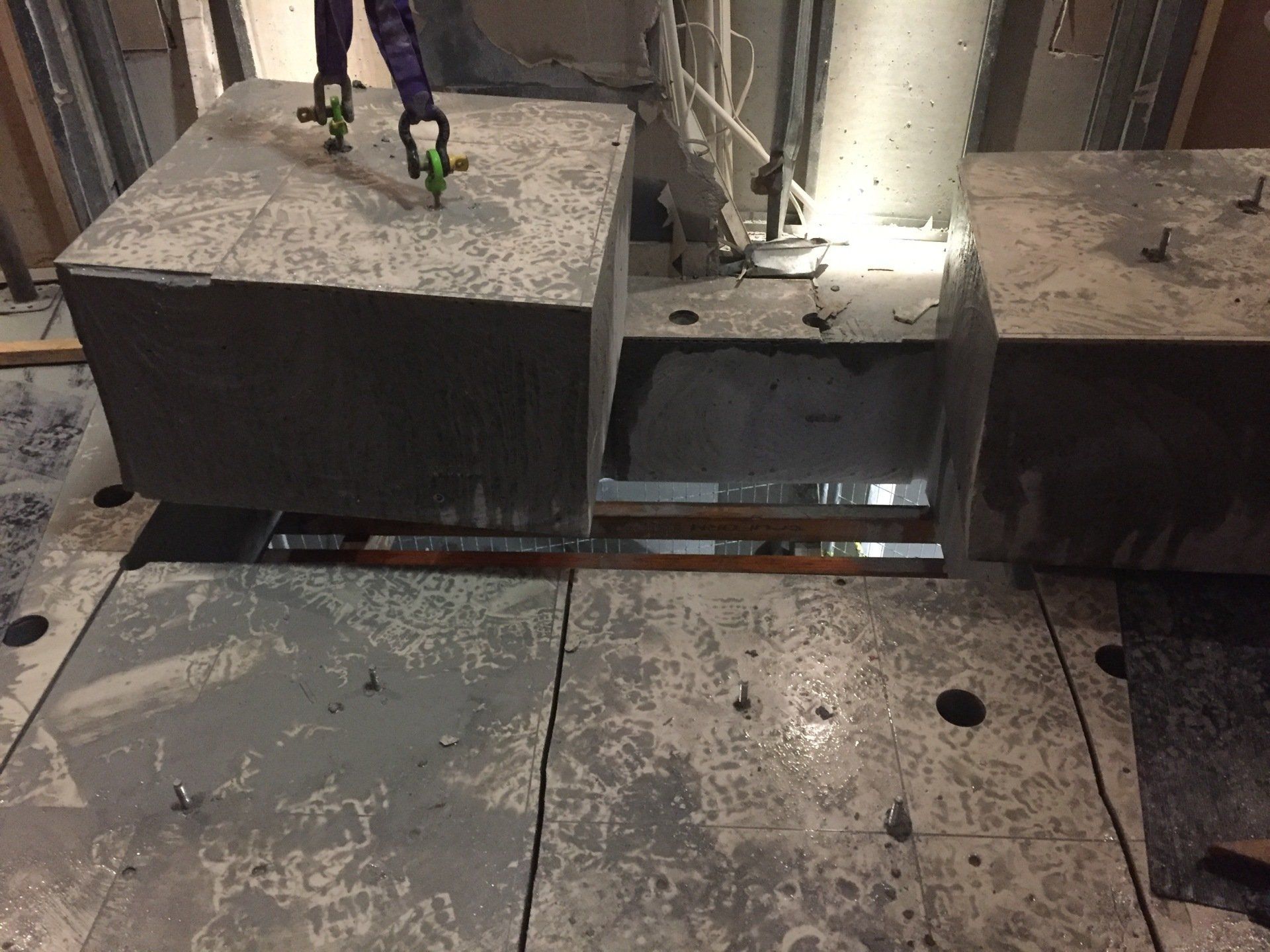 A person is standing on a concrete block in a room.