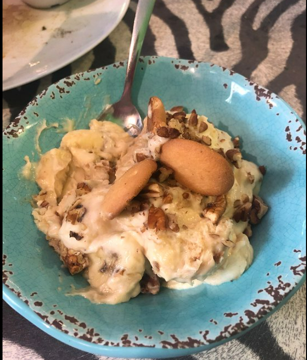 A bowl of banana pudding with a spoon in it