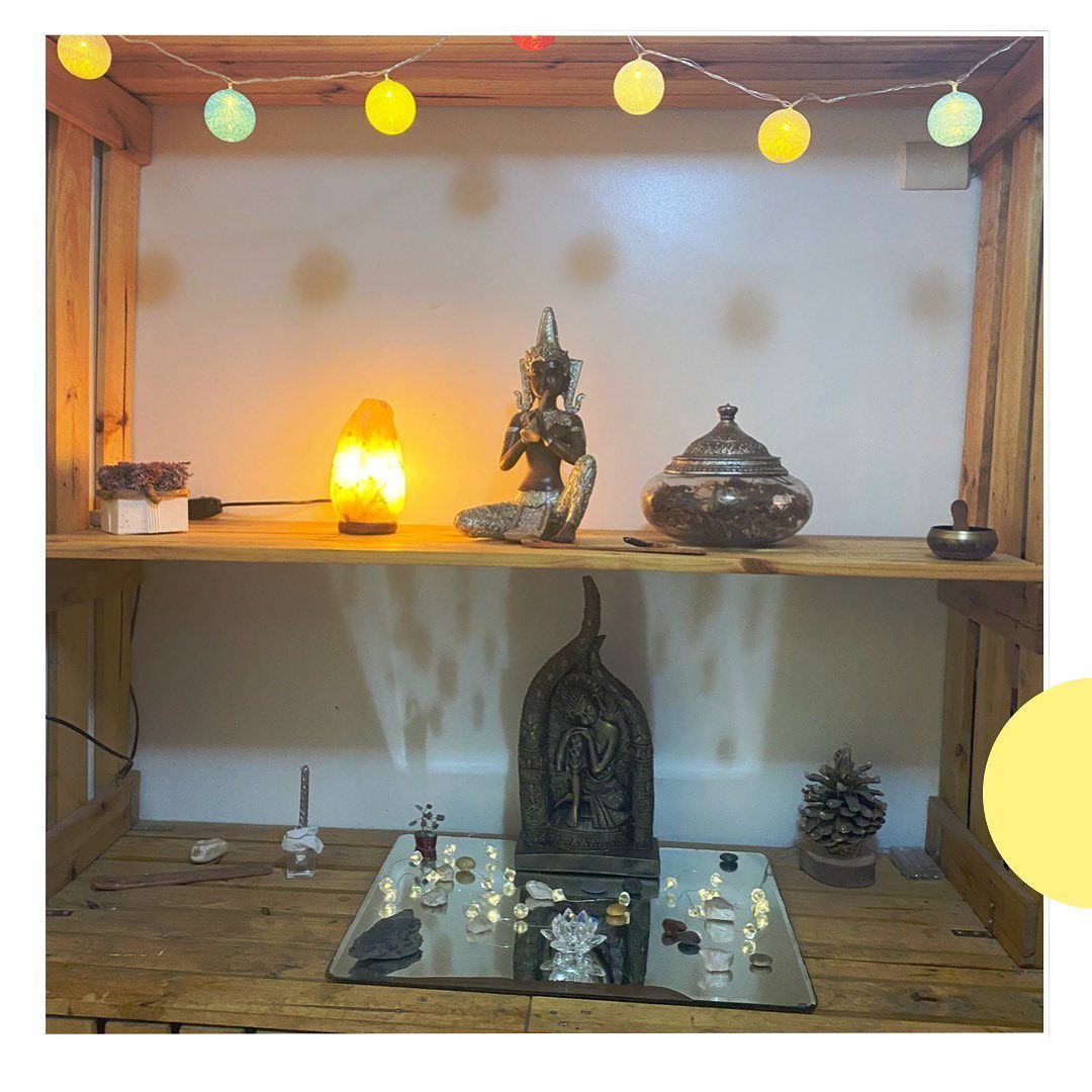 Un estante de madera con una estatua y una lámpara encima.