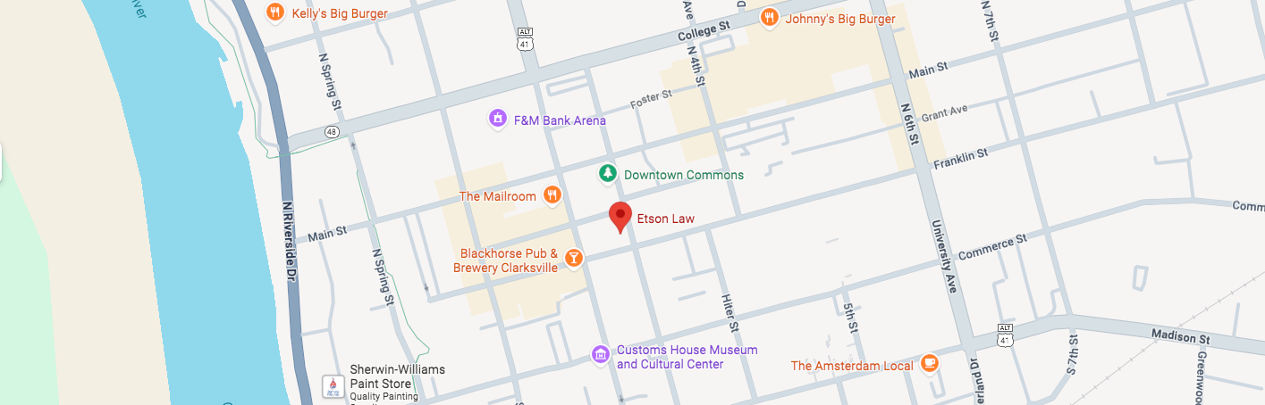 Map of an urban area, featuring a river on the left, roads, buildings, and labeled locations, with a red marker indicating a specific spot.