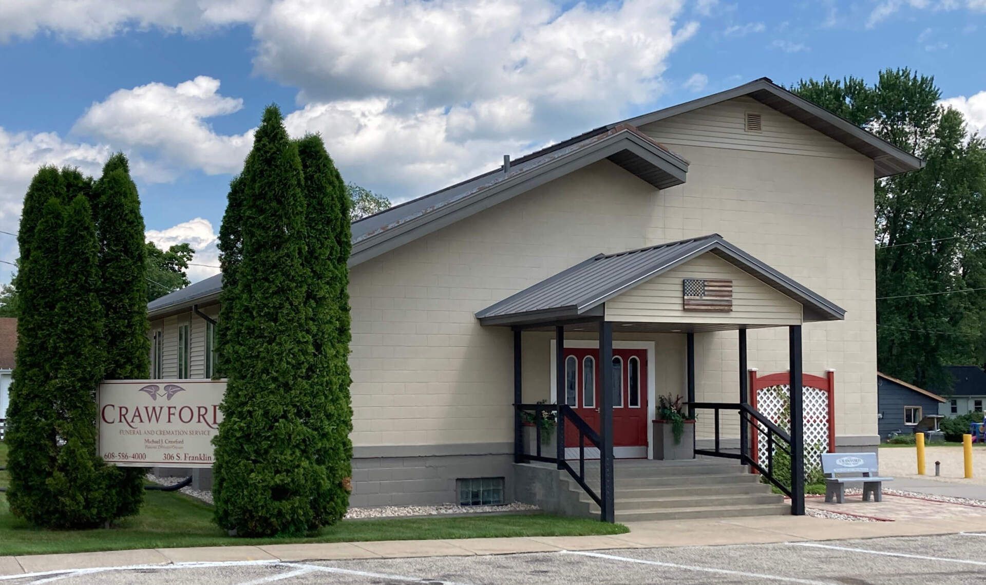 A white building with a red door and a sign that says crawford