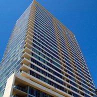 Looking up at a tall building with a blue sky in the background.