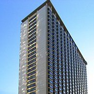 A tall building with a lot of windows against a blue sky.