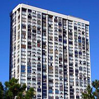 A tall building with a lot of windows against a blue sky.