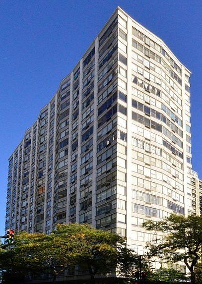 A tall building with lots of windows against a blue sky