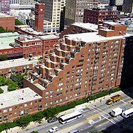 An aerial view of a city with a large brick building in the middle.