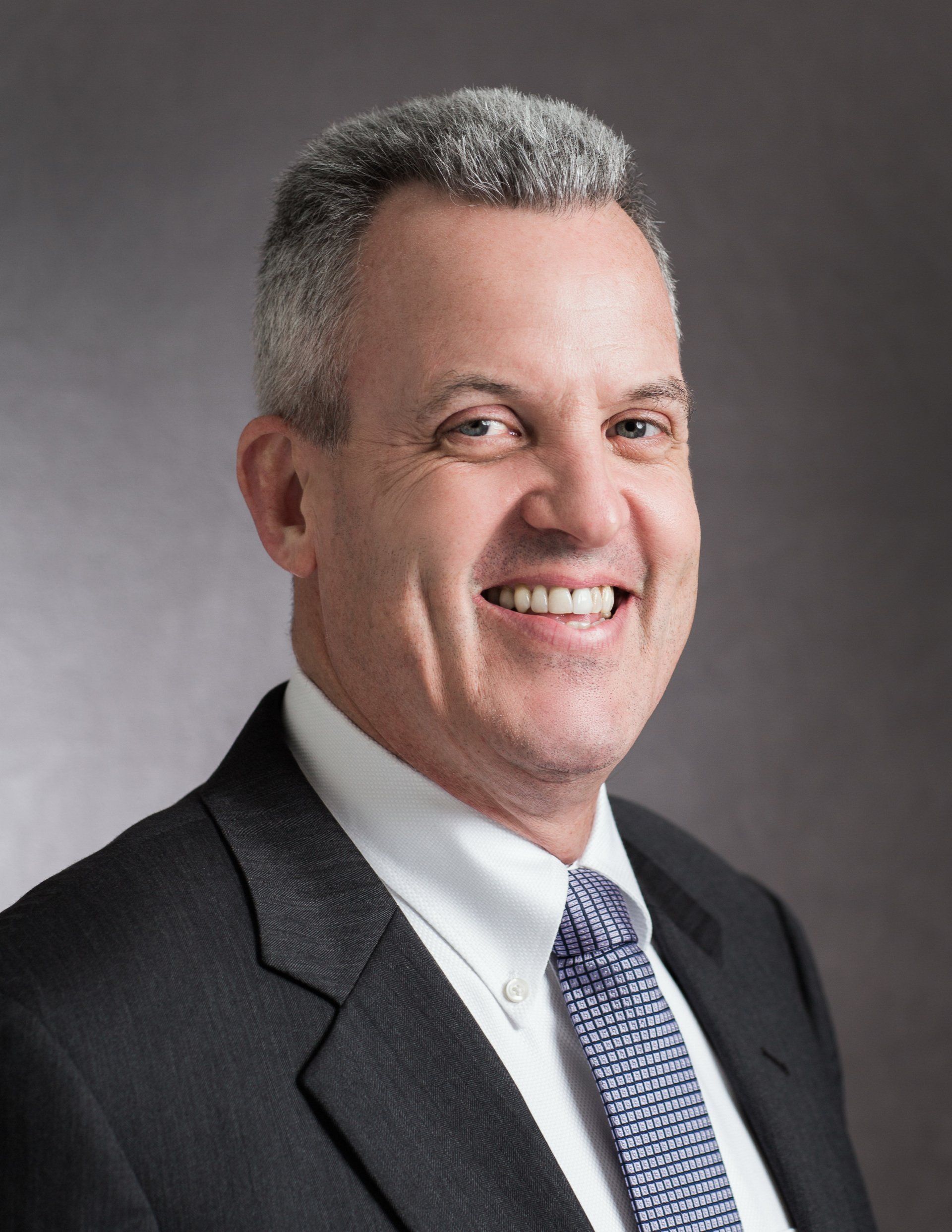 A man in a suit and tie is smiling for the camera.