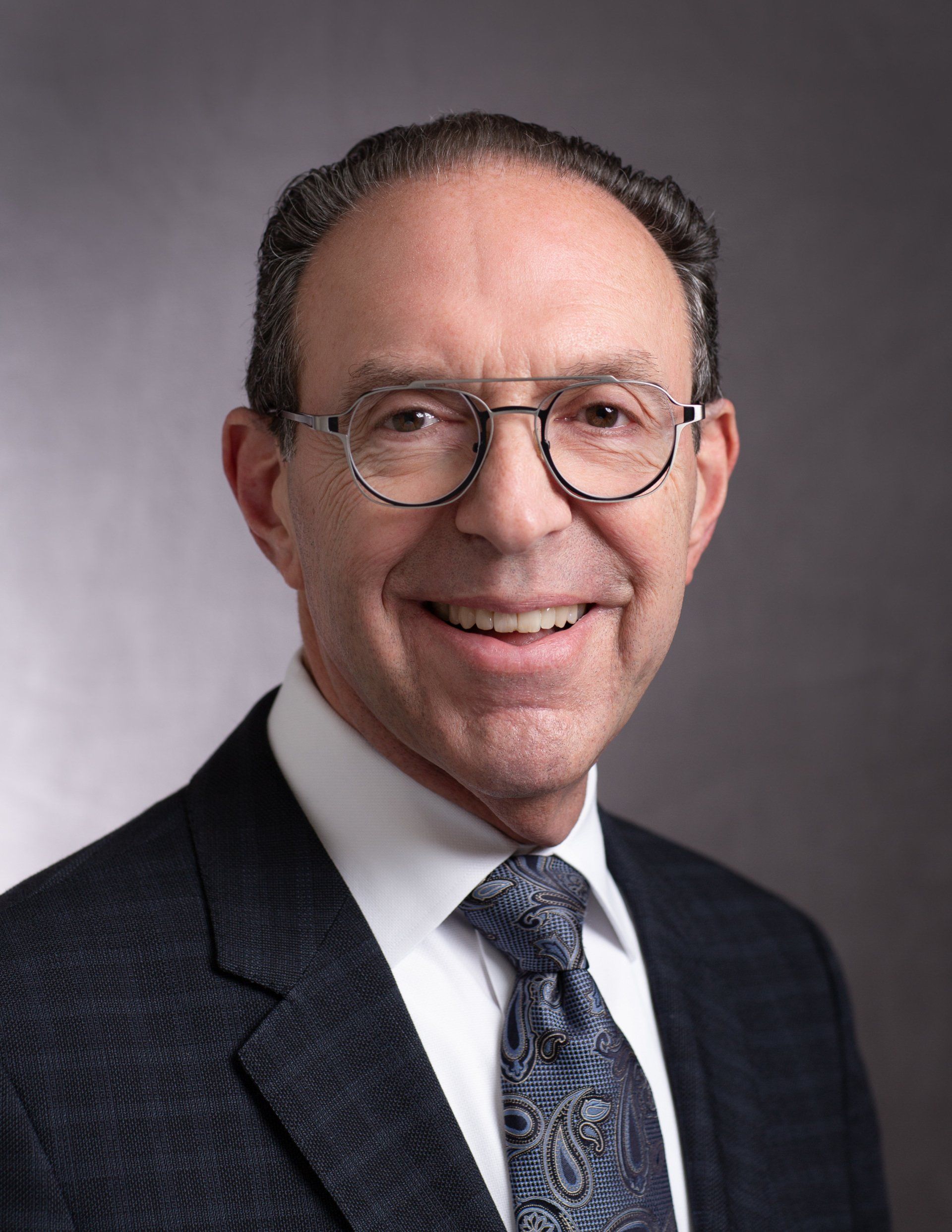 A man in a suit and tie is smiling for the camera.