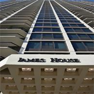 Looking up at a tall building with a sign that says james house.