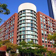 A large brick building with a lot of windows and trees in front of it.