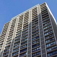A tall building with a lot of windows against a blue sky.