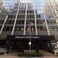 The streeterville center is a large building with a flag in front of it.