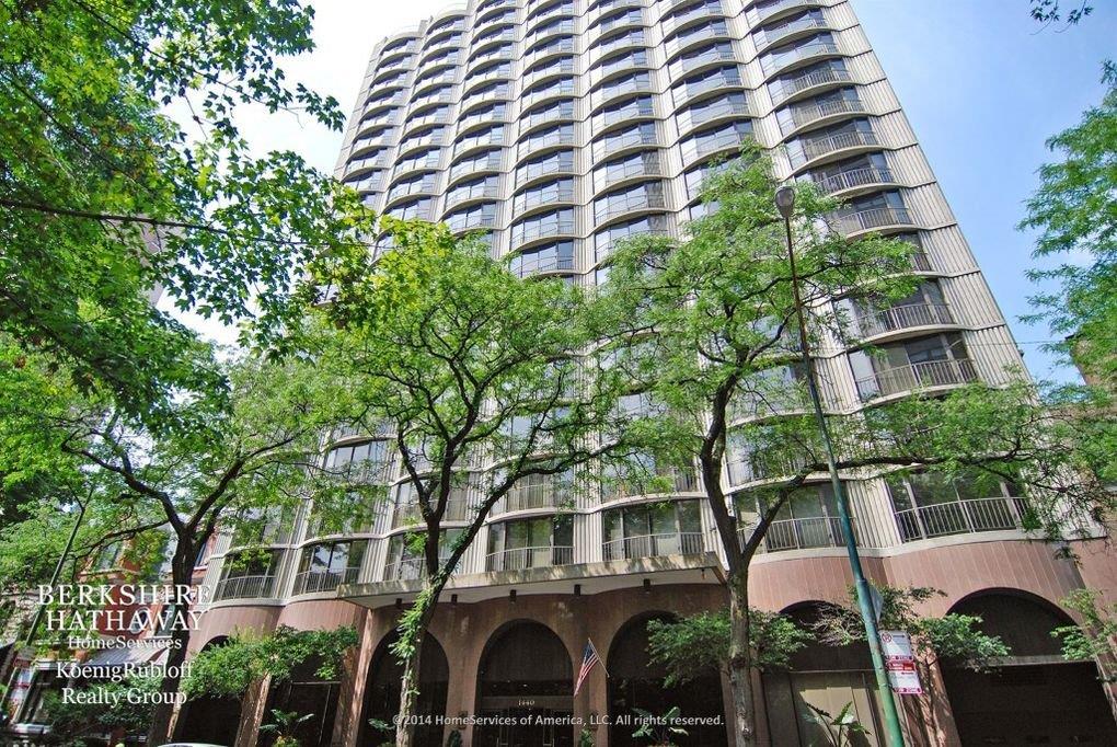 A tall building with lots of windows and trees in front of it