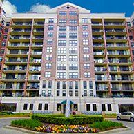 A large apartment building with a fountain in front of it.