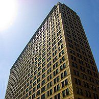 Looking up at a tall building with a blue sky in the background.