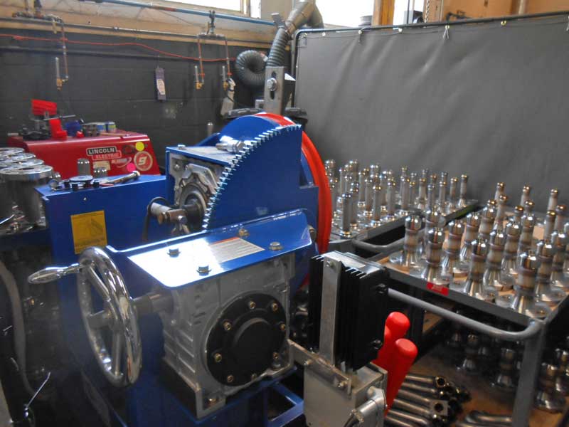 A machine with a steering wheel is in a room with other machines