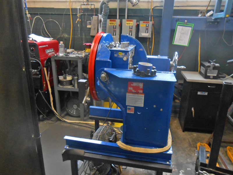 A blue machine is sitting on a table in a workshop