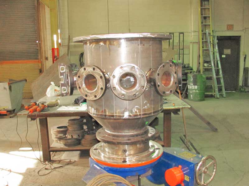 A large metal object is being built in a factory