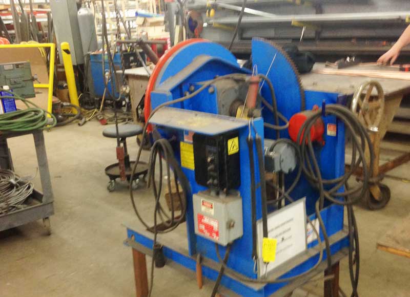 A blue machine is sitting on a table in a factory