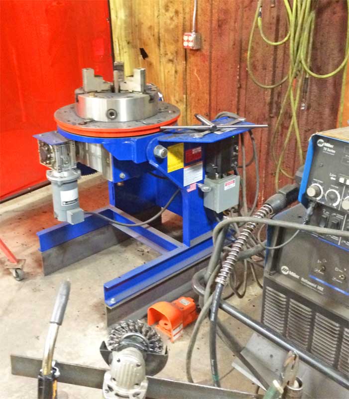 A welding machine is sitting in a room with a red door