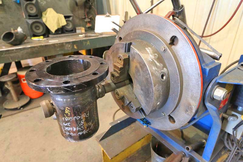 A piece of metal is sitting on top of a machine in a workshop.