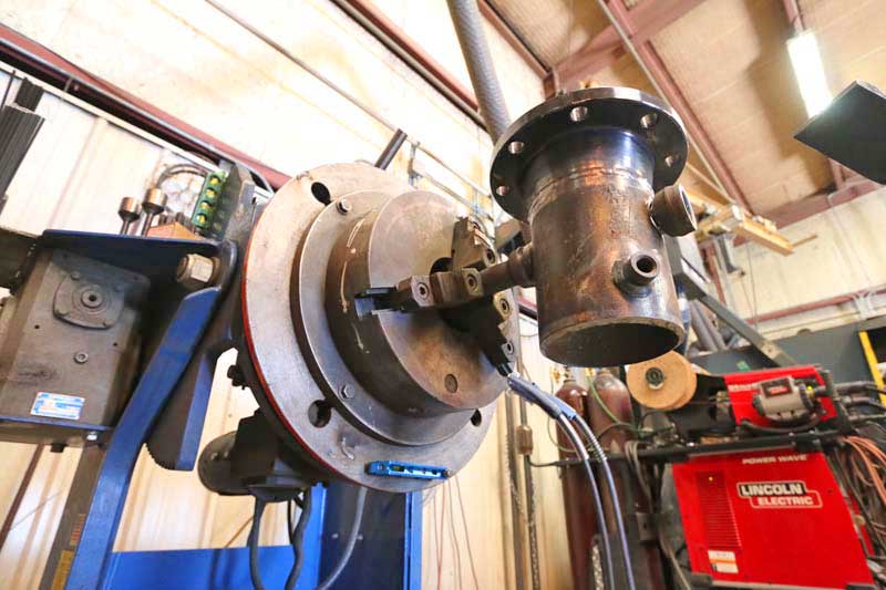 A machine is working on a piece of metal in a factory.