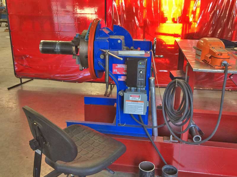 A chair is sitting next to a machine in a factory