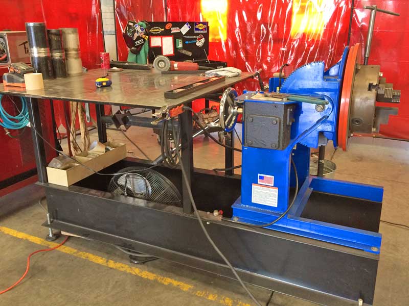 A blue machine is sitting on a cart in a workshop