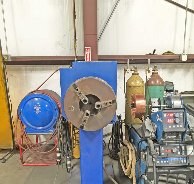 A welding machine is sitting in front of a fire extinguisher