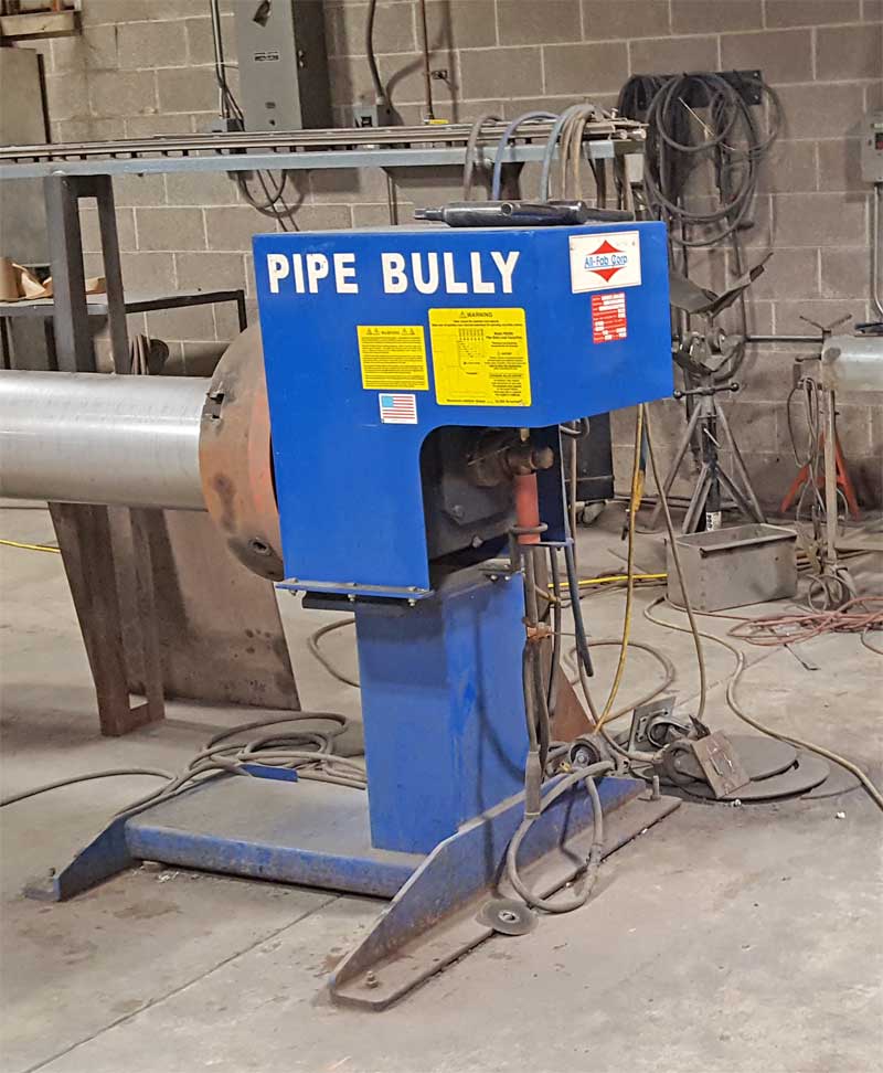 A blue pipe bully machine is sitting in a factory