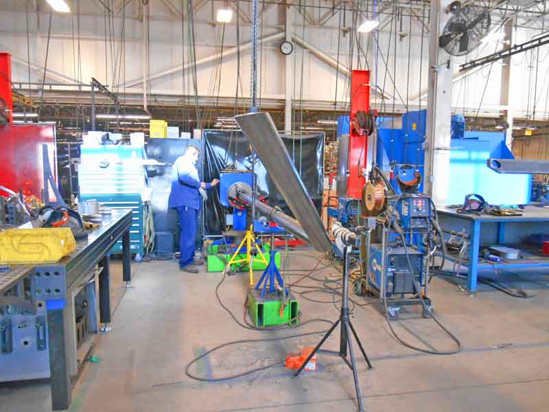 A man is working on a piece of metal in a factory.