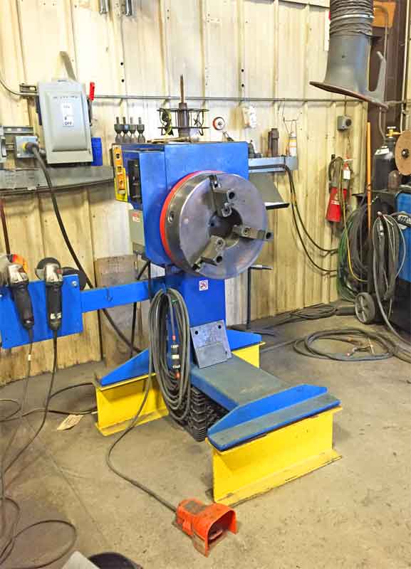 A blue and yellow machine is sitting in a garage.