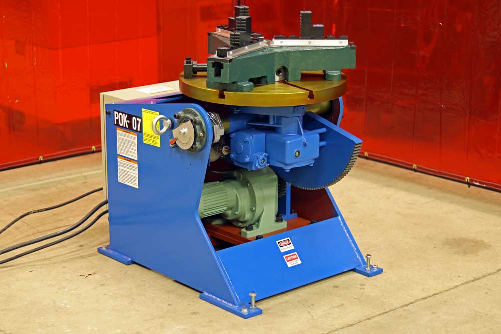 A machine is sitting on the floor in front of a red wall.