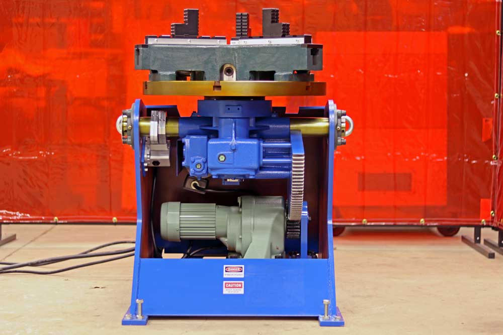 A blue machine is sitting in front of a red curtain.